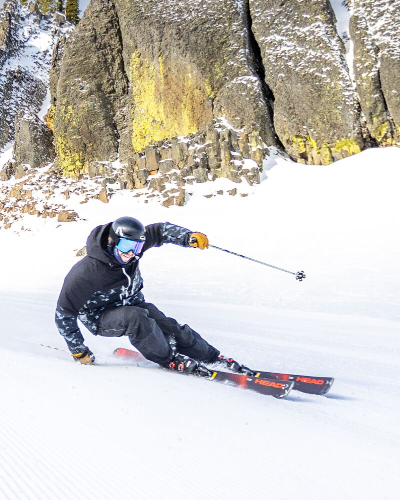 Skier turning with basalt cliffs in background